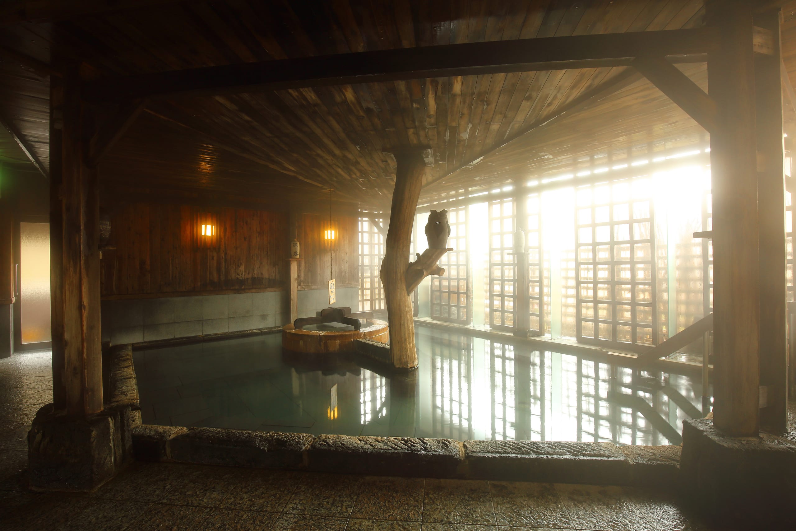Morning light through lattice windows in a traditional wooden onsen bath
